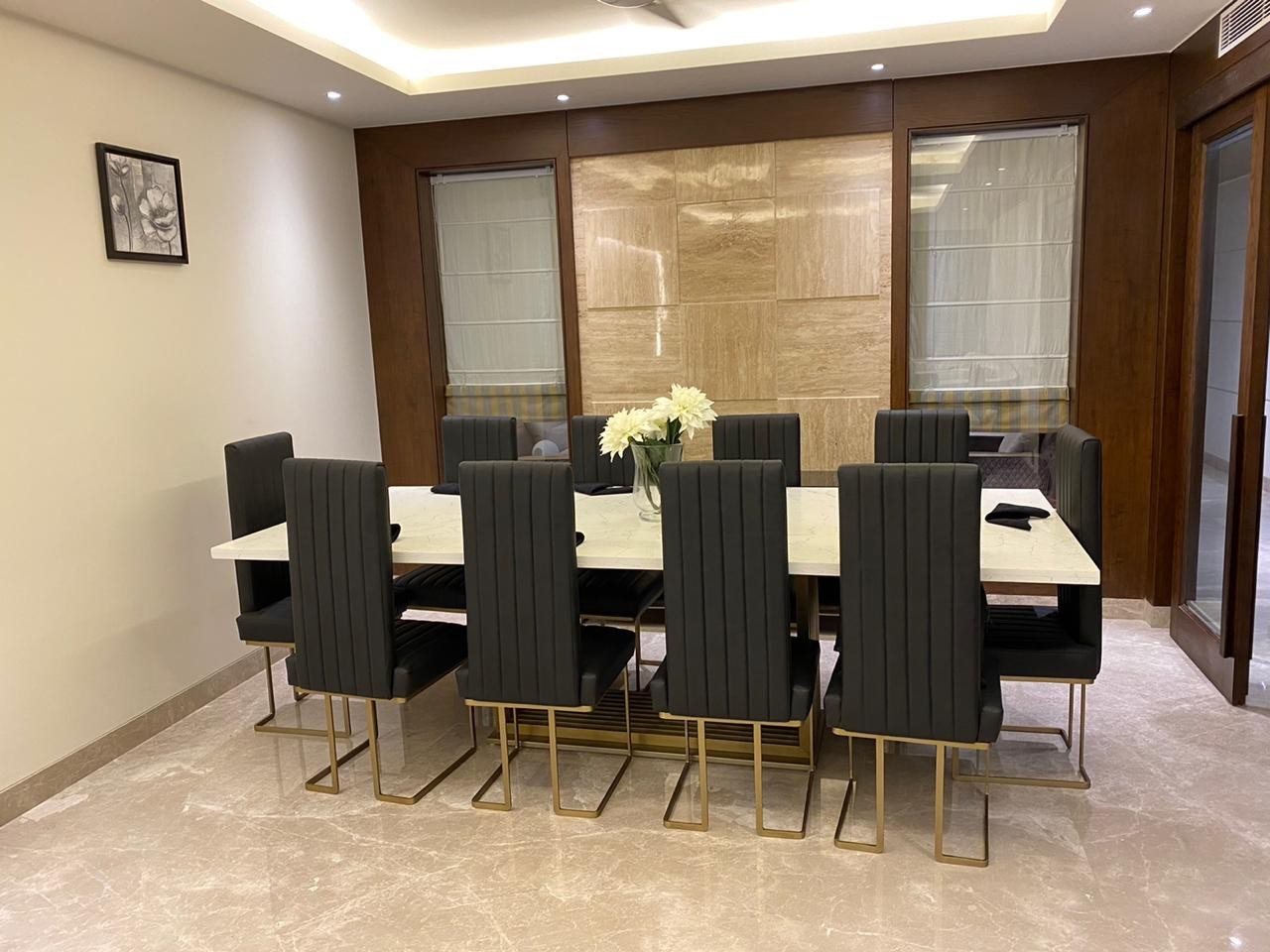 Dining room with a ten-seat table, timber panelling and cove lighting