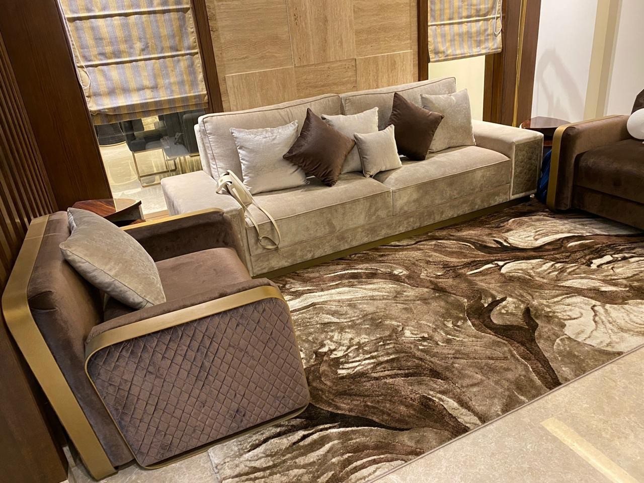 Living room with a cream sofa, stone wall panelling and a patterned rug